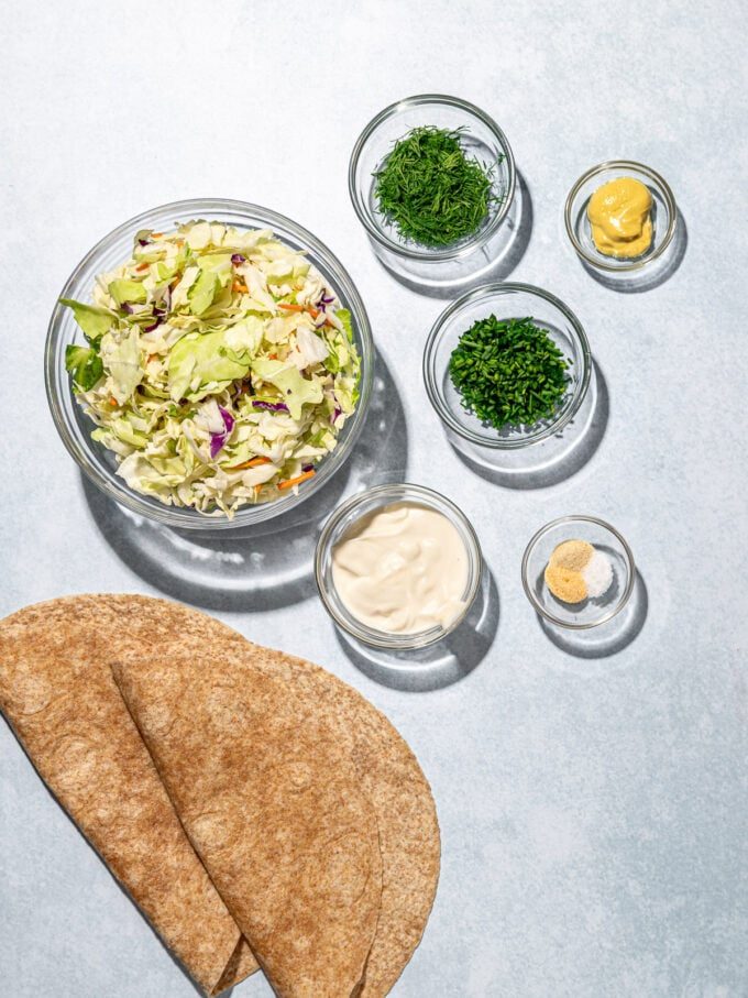 Coleslaw, tortillas and herbs in bowls