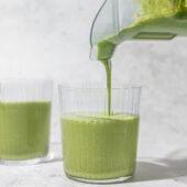 pouring kale smoothie into a glass