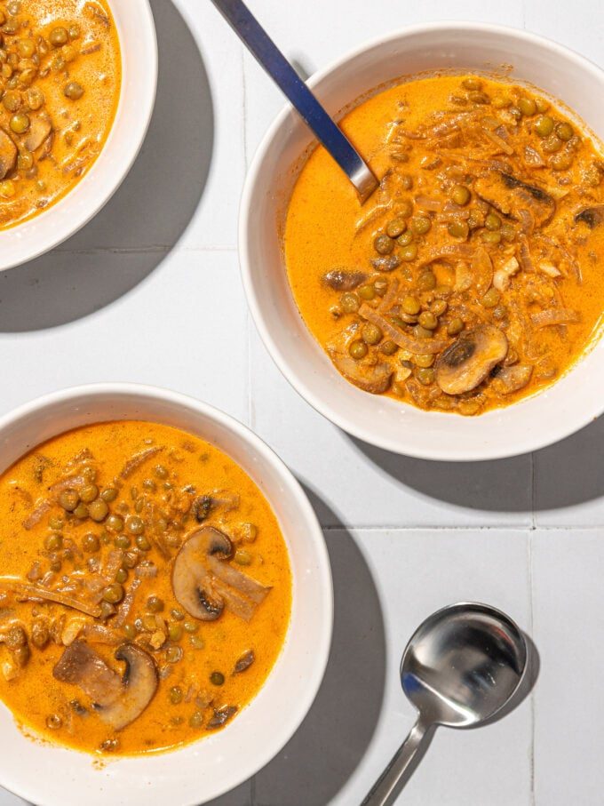 mushroom and lentil stew in white bowls with spoons