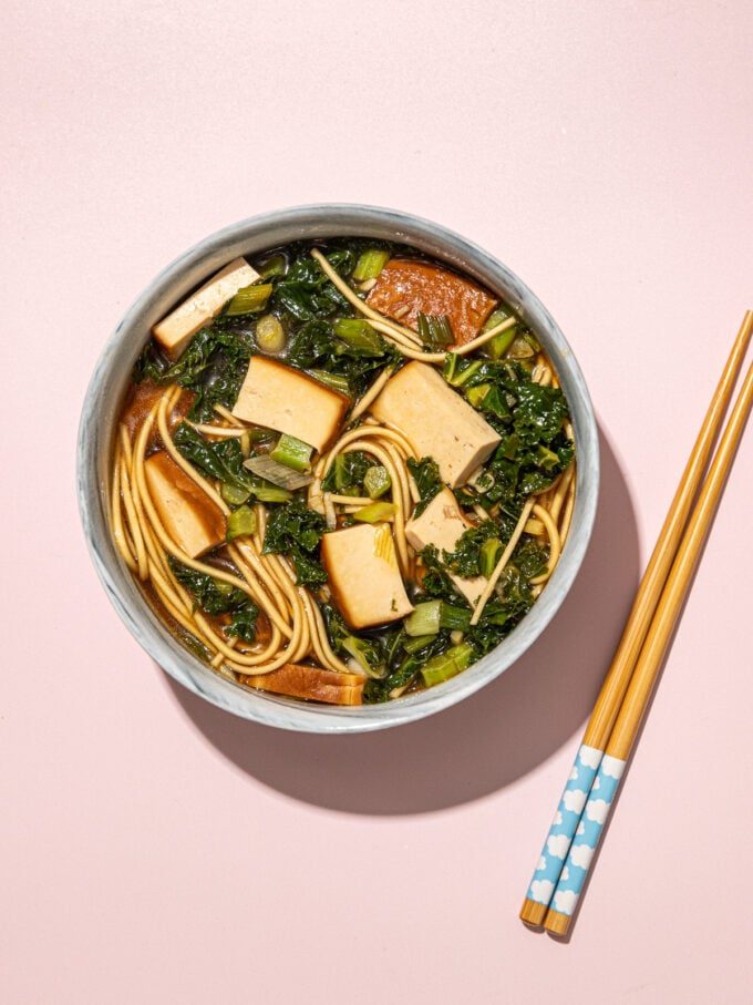 vegan ramen with kale and tofu in bowl with wooden chopsticks