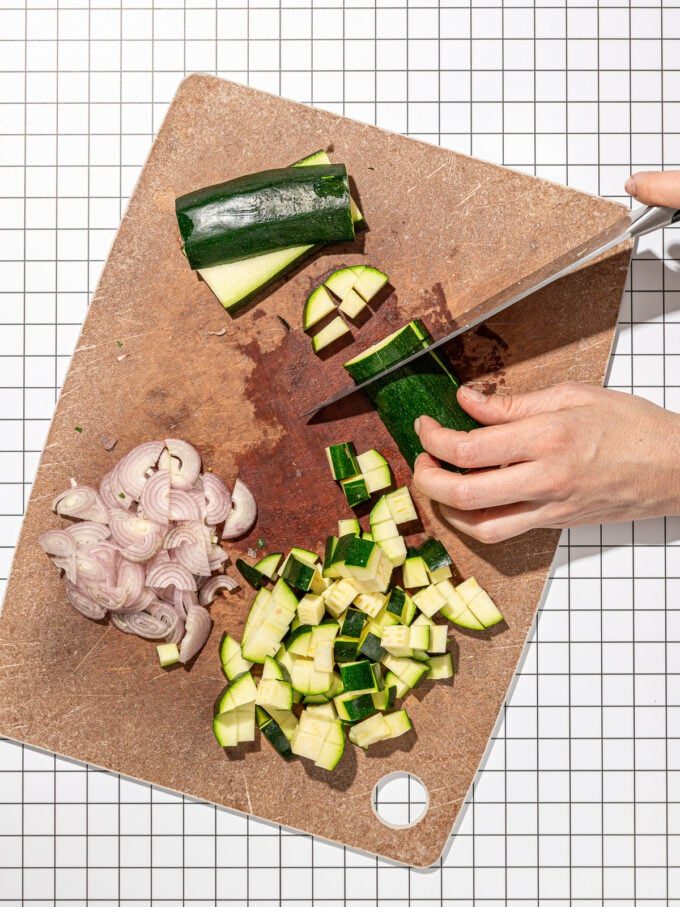 hand chopping zucchini and shallot