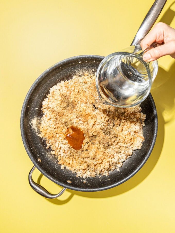 hand pouring water into skillet