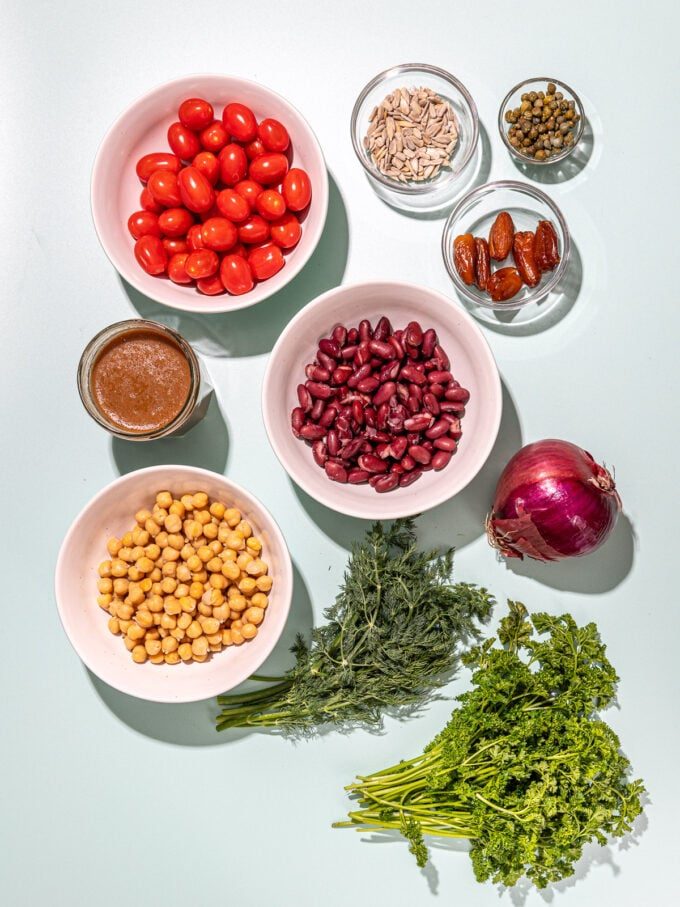 kidney beans, chickpeas, tomatoes in white bowls