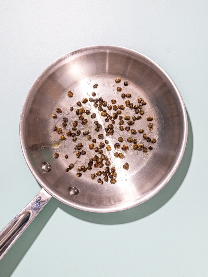 fried capers in metal skillet