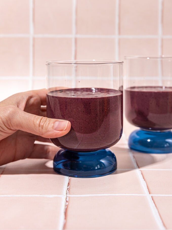 hand holding glass with chocolate cherry smoothie