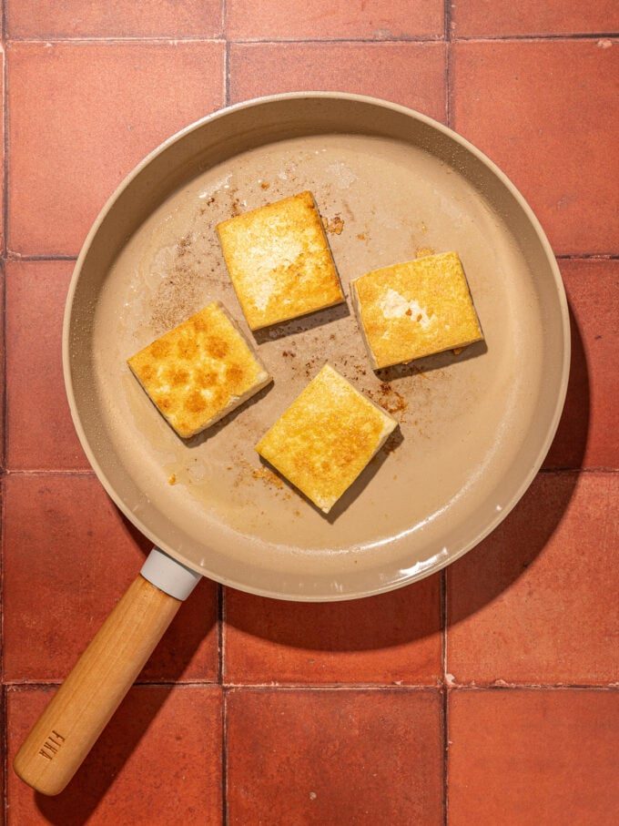 blocks of tofu in beige skillet